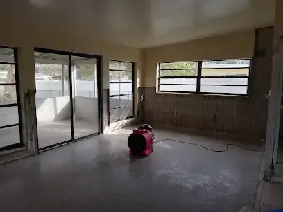 Flood-cut walls and an air mover drying a room after storm water