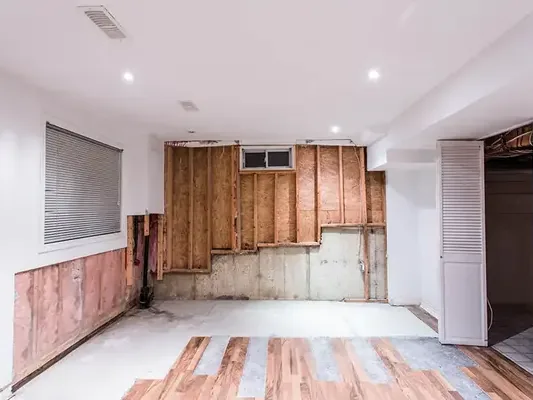 Finished room with wet drywall and insulation stripped out for drying